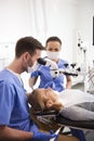 Dentist and his assistant working with dental microscope Royalty Free Stock Photo