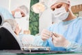 Dentist and his assistant working with a patient in a dentist chair in dentist office Royalty Free Stock Photo