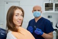 A dentist is holding a dental mirror and dental explorer near a female patient Royalty Free Stock Photo