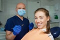 A dentist is holding a dental mirror and dental explorer near a female patient Royalty Free Stock Photo