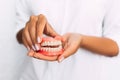 The dentist is holding dentures in his hands. Dental prosthesis in the hands of the doctor close-up. Front view of complete