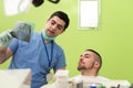 Dentist Holding X-Ray And Examse White Patient