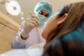 Dentist Indian in mask and gloves examining patient's teeth