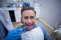 Dentist injecting anesthetics in scared male patient mouth Royalty Free Stock Photo