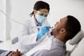 Dentist Lady In Medical Mask Treating Male Patient& x27;s Teeth With Dental Drill