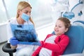 Dentist and little girl looking at x-ray of teeth