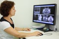 Dentist looks jaw X-rays at computer monitor