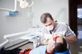 Dentist makes teeth treatment.