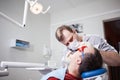 Dentist makes teeth treatment.