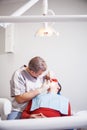 Dentist makes teeth treatment.