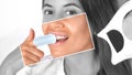 The dentist makes a teeth whitening procedure in the clinic to a young beautiful woman. The woman cleans her teeth. A healthy