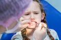 Dentist making teeth examination procedure for little girl sitting on chair in Dentist office Royalty Free Stock Photo