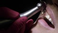 Dentist making tooth cleaning for patient