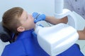 Dentist making x-ray of teeth for teenage boy child in dental clinic, side view.