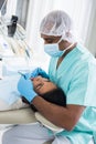 Dentist male in uniform is examinating of female in clinic