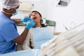 Dentist male in uniform is examinating of female in clinic