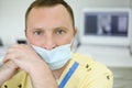 Dentist in mask looks at camera in dental clinic