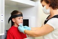 Dentist in mask prepares boy to jaw x-ray image Royalty Free Stock Photo