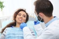 Dentist matching patient`s teeth color with palette