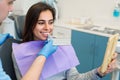 Dentist matching patient`s teeth color with palette in office