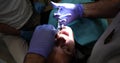 Dentist in medical gloves injects anesthesia into young woman tooth in dental office