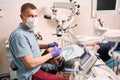 Dentist in medical mask examining patient teeth in dental office. Royalty Free Stock Photo