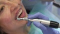 Dentist moves prophy cup across upper incisors