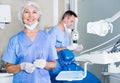 Dentist near dental chair, welcoming patient to office