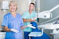 Dentist near dental chair, welcoming patient to office