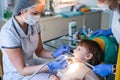 Dentist and nurse curing childe teeth