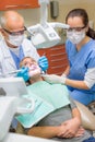 Dentist with nurse doing procedure on patient