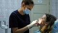 Dentist orthodontist puts a dental fixator for a woman to install a bracket system. Visit to the dentist Royalty Free Stock Photo