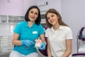 Dentist and patient choose treatment during consultation in beautiful clinic.