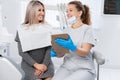 Dentist and patient choose treatment in consultation with medical equipment in the background. smiling woman dentist