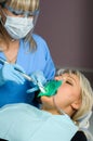 Dentist with patient, using dental curing light