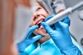 Dentist performing dental filling procedure to preteen girl in pediatric dental clinic