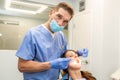 Dentist performing teeth treatment with female patient open mouth