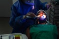 Dentist performing a teeth whitening procedure with a client