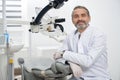 Dentist posing on workplace in modern clinic.