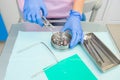 A dentist prepares a latex scarf with metal clips