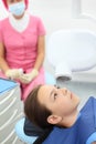 Dentist prepares to make jaw x-ray image for girl