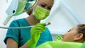 Dentist preparing to drill sick tooth, brave teenage girl waiting for procedure