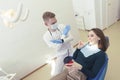 dentist proves to the patient that harmful products spoil her teeth