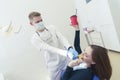 dentist proves to the patient that harmful products spoil her teeth