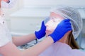 Dentist puts protective glasses on patient woman before teeth cure in dentistry.