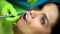 Dentist putting cotton ball in female patient mouth, isolation from saliva