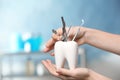 Dentist putting professional tool into tooth shaped holder in clinic