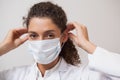 Dentist putting on surgical mask looking at camera