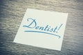 Dentist Reminder On Paper Lying On Wooden Cupboard