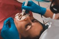 At the dentist`s appointment, tartar removal, use of ultrasound, patient and dentist. Retractor for isolation of lips and gums Royalty Free Stock Photo